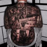 A person's back featuring a large, intricate black and grey tattoo of a gangster theme.
