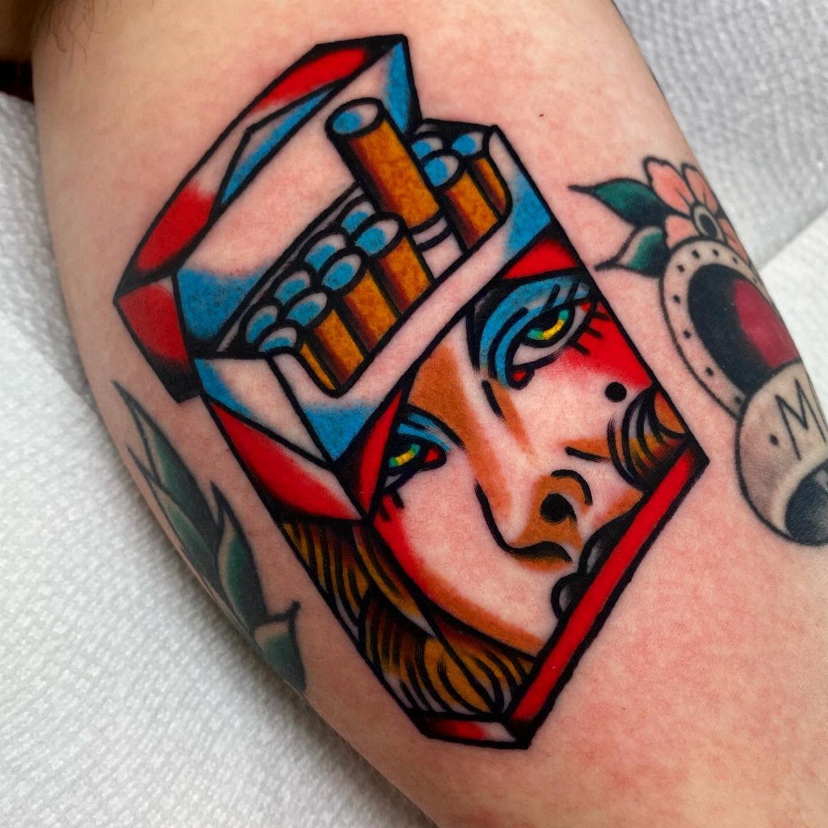Traditional Lady Tattoo: 9 Designs for Every Style 5 A neo-traditional tattoo of a woman's face combined with a pack of cigarettes on skin.