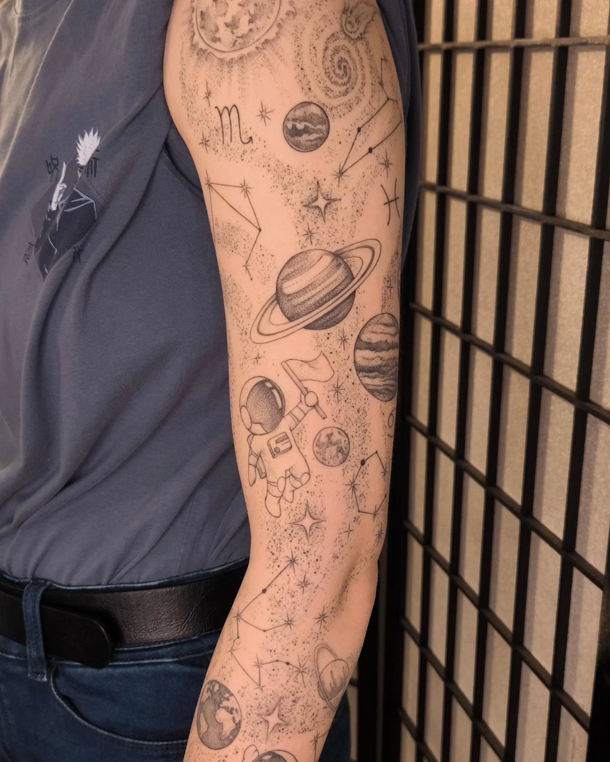 25 Space Themed Tattoos from Watercolor Cats to Black Holes 26 A person's arm covered in detailed black ink space themed tattoos including planets and constellations.