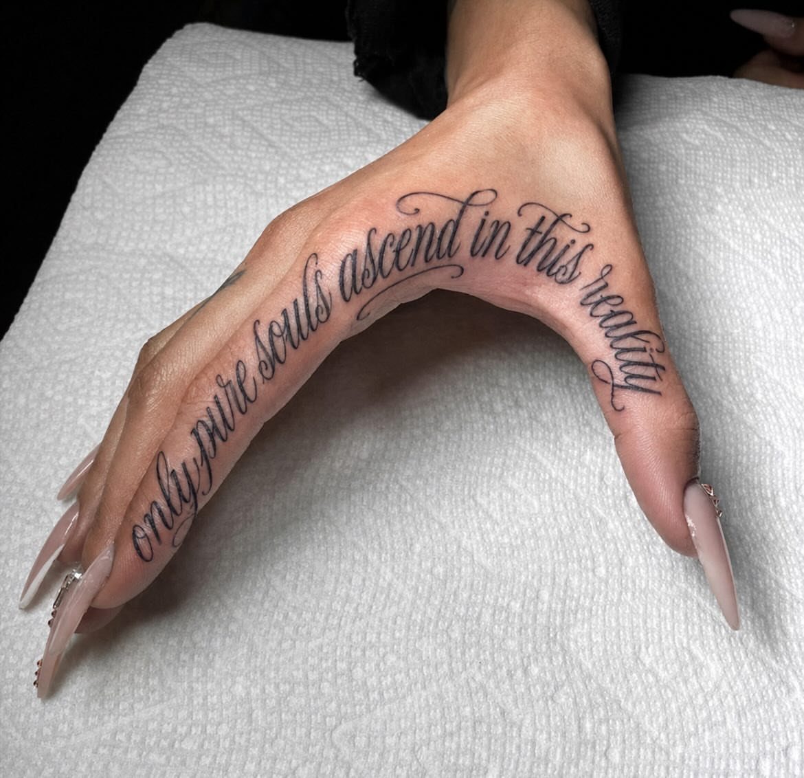 Tattoo Style Words: 7 Ways Lettering Takes Shape on Skin 8 A hand with a script tattoo reading 'only pure souls ascend in this reality' on the skin.