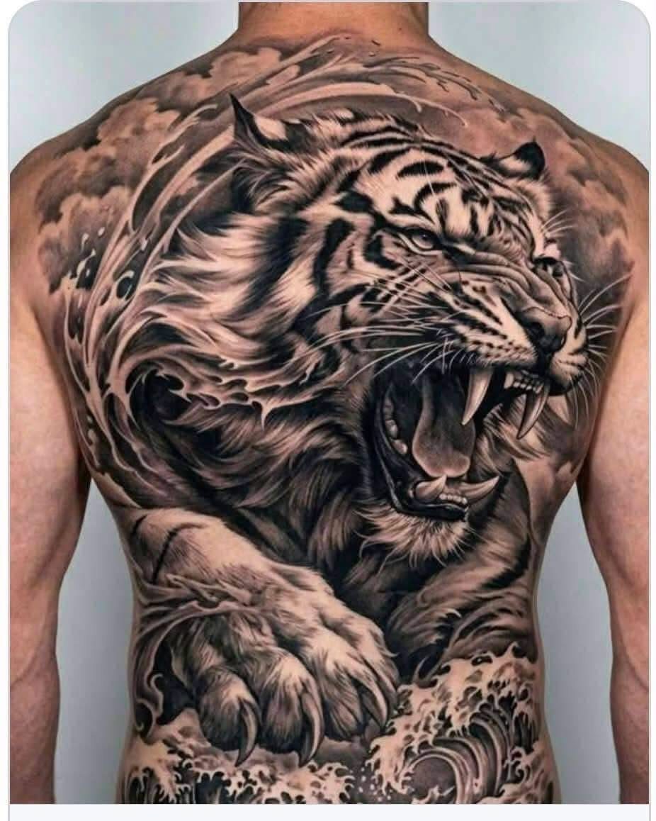 Back Pieces Tattoo: 7 Designs That Use the Whole Canvas 5 A large black and grey tiger tattoo covering a person's entire back with swirling water patterns.