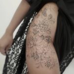 A large black and grey floral tattoo covering a person's hip and upper thigh.