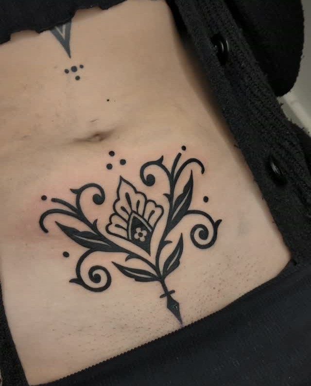 Tattoo Placement: 8 Lower Stomach Ideas for Your Next Ink 5 A black ink floral ornament tattoo placed on a person's lower stomach area.