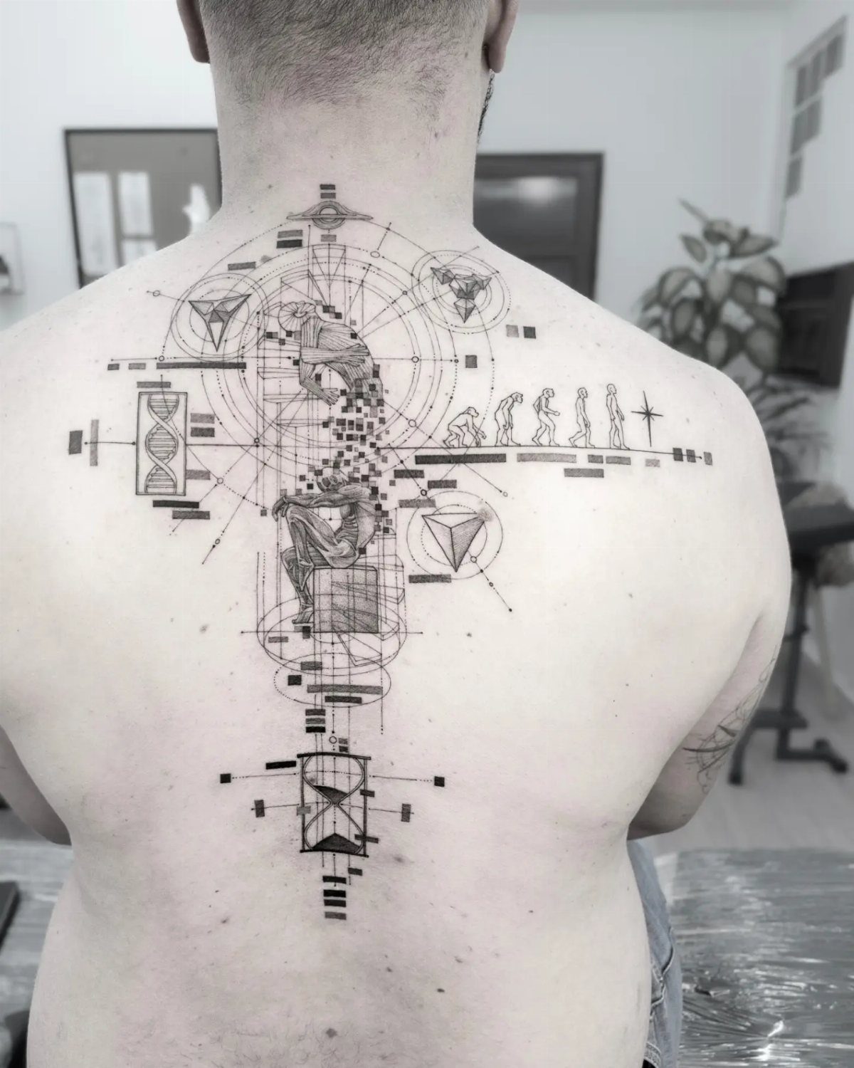Back Pieces Tattoo: 7 Designs That Use the Whole Canvas 6 A large black ink geometric tattoo covering a person's upper and middle back.