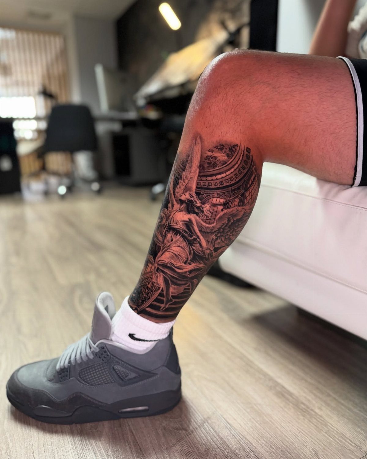 A detailed black and grey tattoo covering a person's lower leg and calf area.