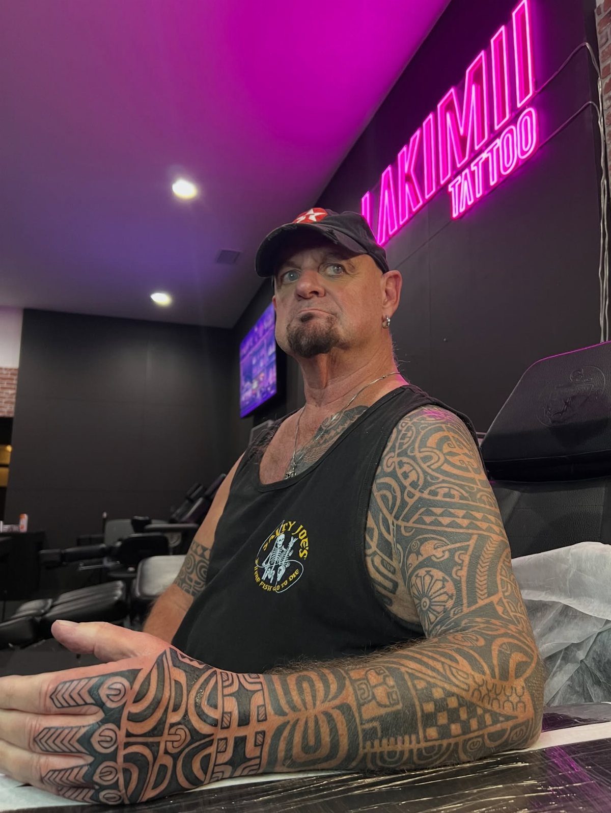 Polynesian Tattoo Pattern: 16 Island Styles From Marquesan to Maori 2 A man displaying dense, geometric Marquesan style tattoos covering his arms and hands.