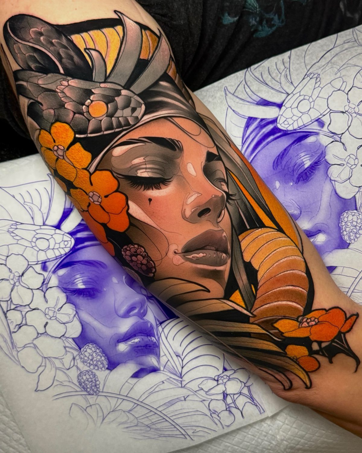 Traditional Lady Tattoo: 9 Designs for Every Style 3 A colorful neo traditional tattoo of a woman's face with feathers and orange flowers on an arm.