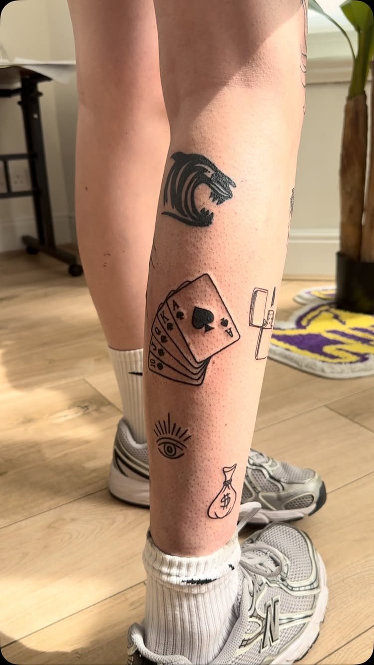 Leg Tattoo Base: 14 Placements from Ankle to Full Sleeve for 2026 8 A person's leg displaying several small black ink patchwork style tattoos.