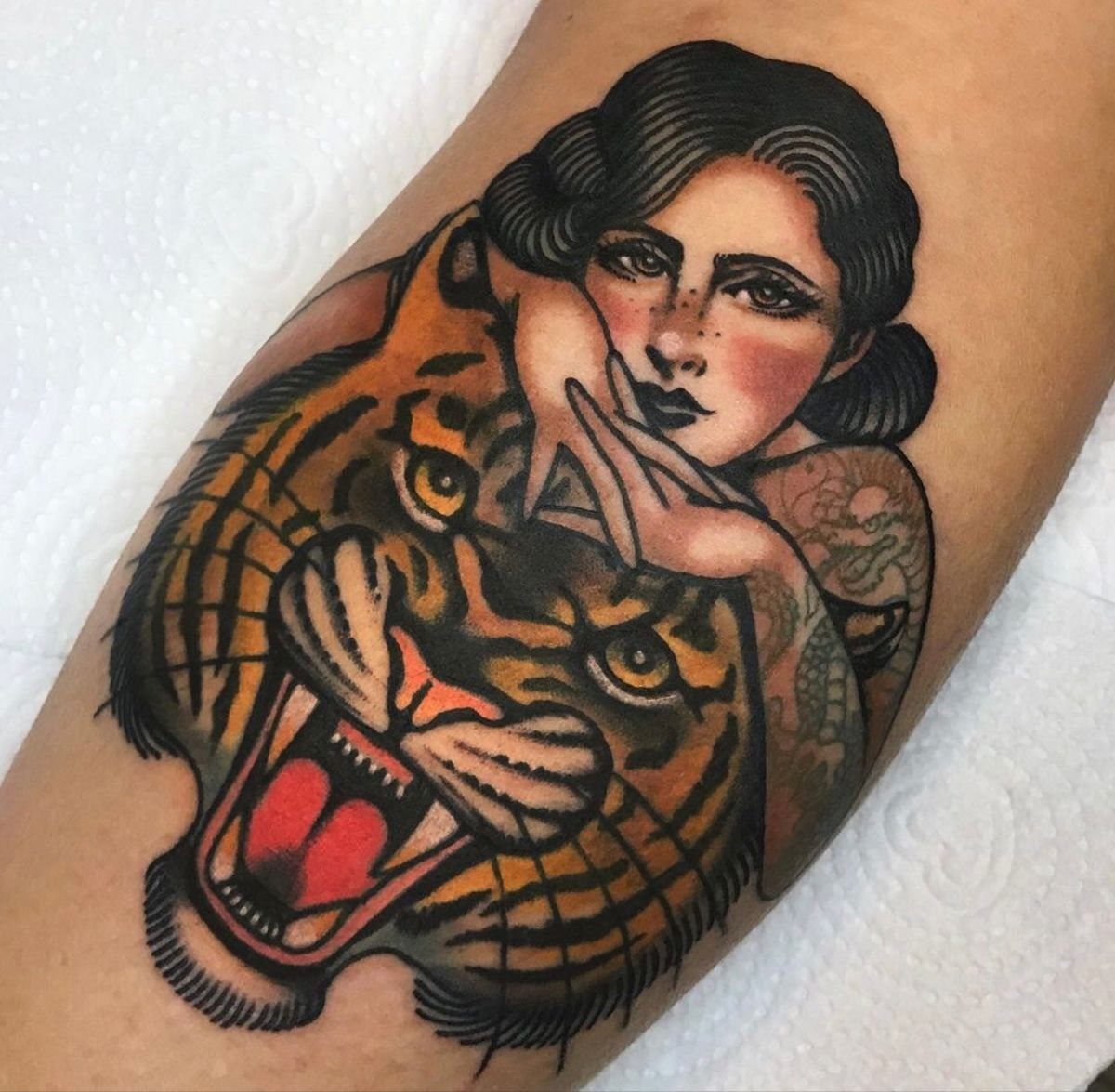 Traditional Lady Tattoo: 9 Designs for Every Style 4 A traditional style tattoo of a woman's face next to a roaring tiger head.