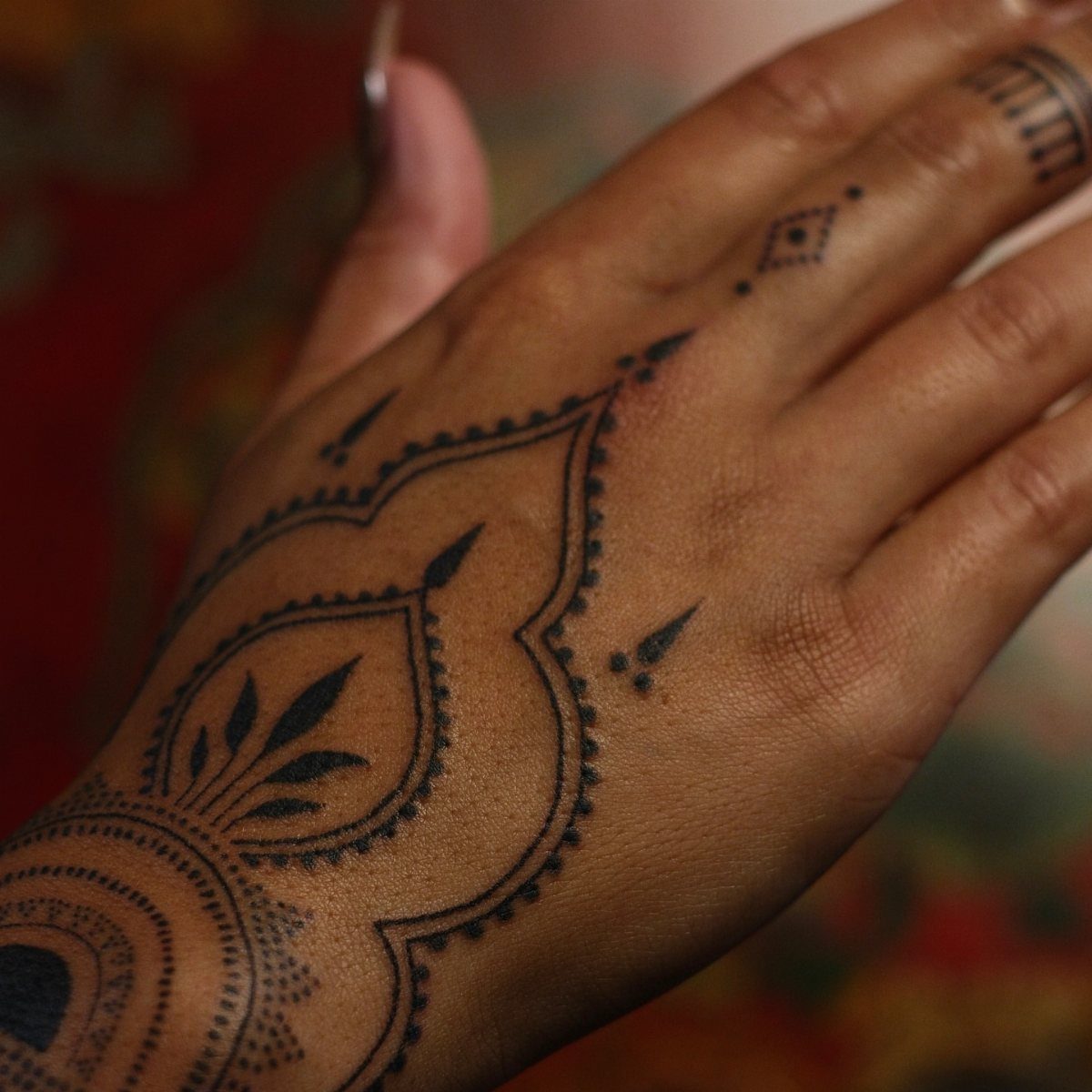 Tattoo Henna Simple: 9 Easy Designs for Hands, Fingers & Shoulders 5 A hand decorated with intricate black henna patterns including floral and geometric dot designs.