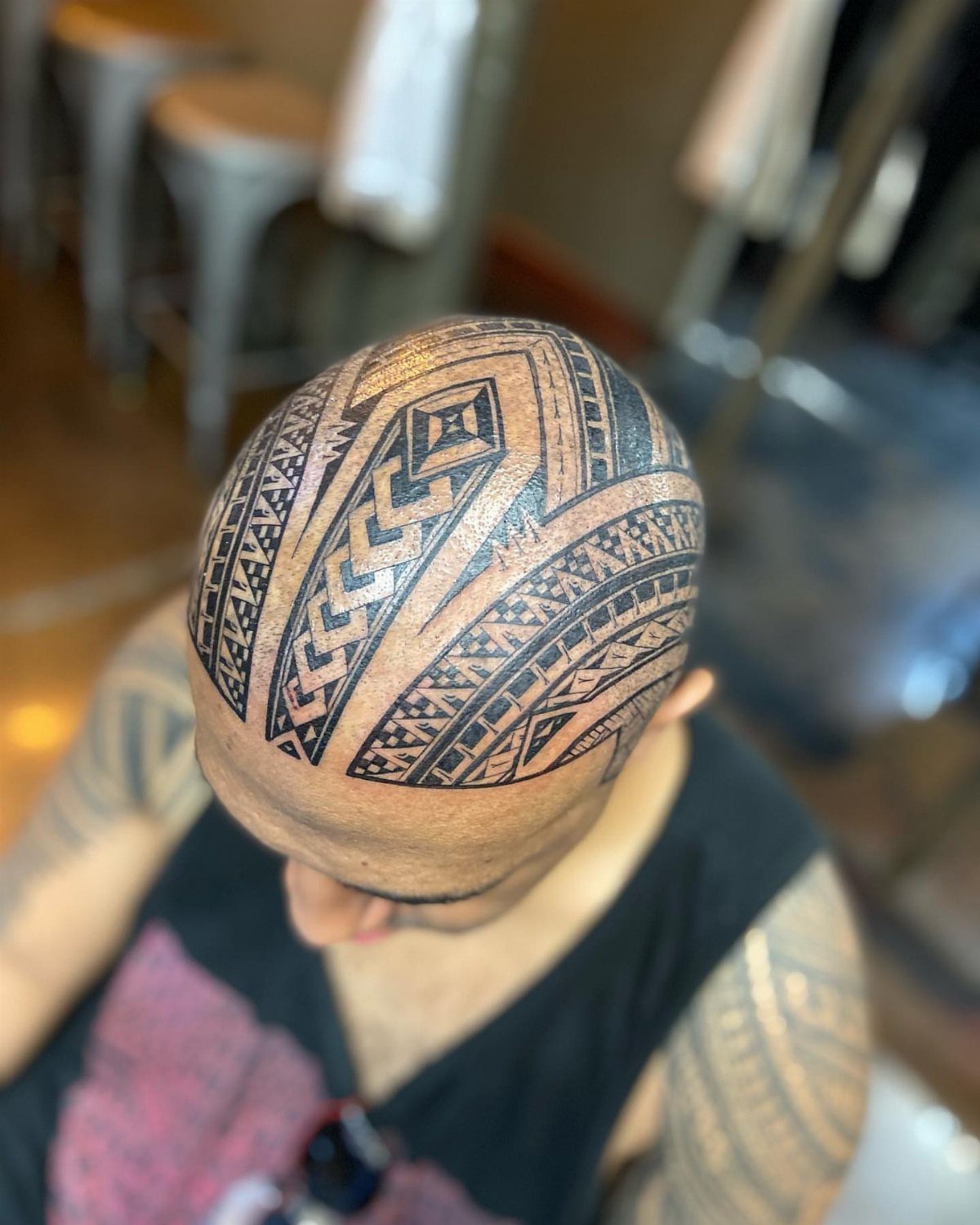 Polynesian Tattoo Pattern: 16 Island Styles From Marquesan to Maori 6 A man's bald head decorated with intricate black Polynesian geometric tattoo patterns.