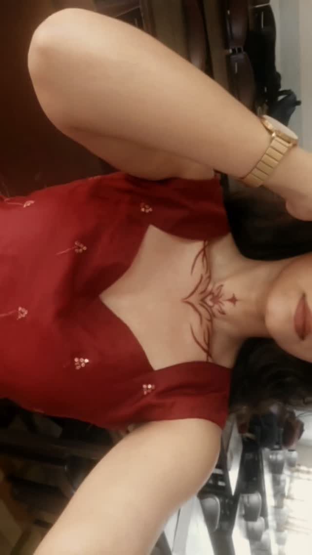 9 Chest Tattoo Ideas for Women: Floral, Sternum, Underboob & More 2026 5 A woman with a delicate red line tattoo on her upper chest and collarbone area.